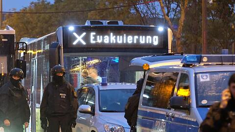 Ein Bus mit der Aufschrift "Evakuierung" wird von Polizei eskortiert . Bei Schüssen in Halle sind zwei Menschen getötet worden.