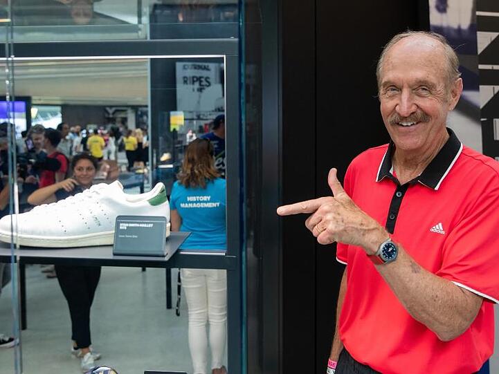 Der frühere Tennis-Star Stan Smith zeigt bei einer Markenausstellung in Herzogenaurach neben "seinem" Schuh.