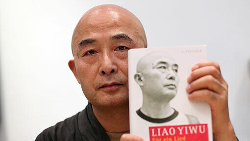 Der chinesische Schriftsteller Liao Yiwu am 27.08.2011 in Erlangen (Mittelfranken) beim Erlanger Poetenfest mit seinem jüngsten Werk "Für ein Lied und hundert Lieder". Yiwu saß mehrere Jahre in China im Gefängnis und war im Juli über Vietnam nach Deutschland gelangt. Der chinesische Schriftsteller Liao Yiwu am 27.08.2011 in Erlangen (Mittelfranken) beim Erlanger Poetenfest mit seinem jüngsten Werk "Für ein Lied und hundert Lieder". Yiwu saß mehrere Jahre in China im Gefängnis und war im Juli über Vietnam nach Deutschland gelangt.