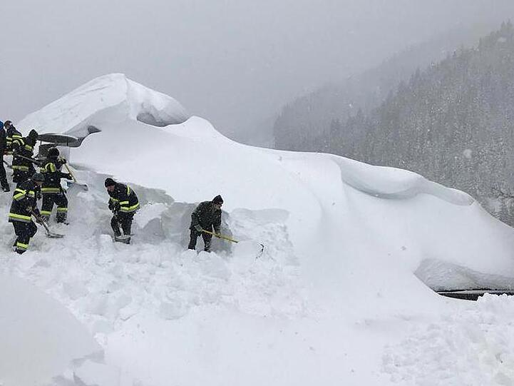 Darunter liegt ein Haus: Feuerwehrleute beim Freilegen eines Daches im österreichischen Pölstal.