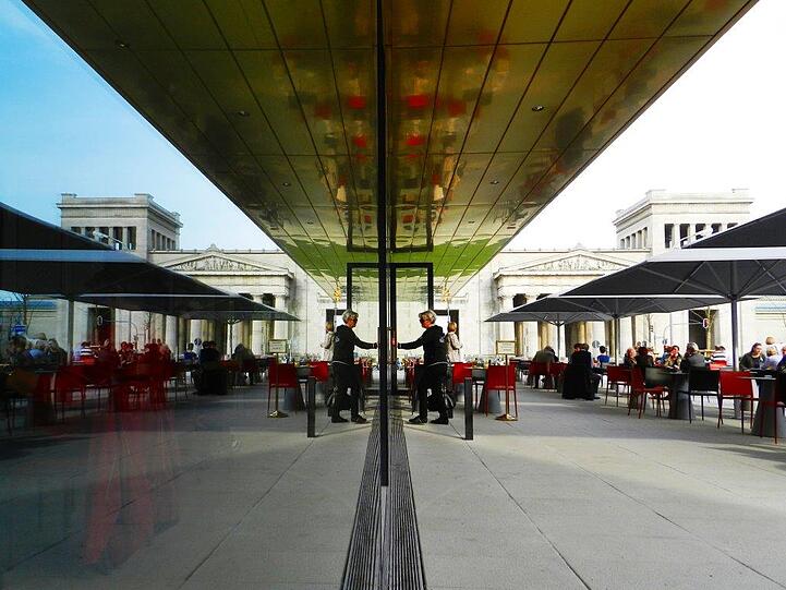 In der Glasfassade des neuen Restaurants Ella bei der Lenbachgalerie spiegeln sich die altehrwürdigen Nachbarn.