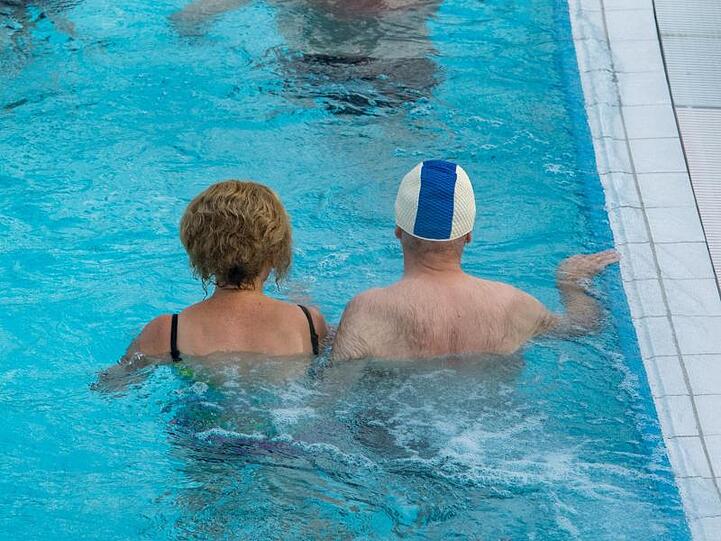 Kurgäste stehen im Wasser der Europatherme in Bad Füssing. Foto: Armin Weigel/dpa/Archivbild