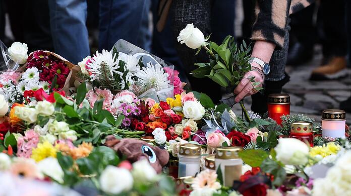 Menschen gedenken der Toten und Verletzten nach der Todesfahrt in Magdeburg.