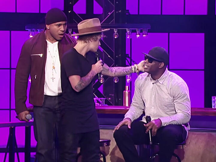 Gastgeber LL Cool J (l.) hat schon begriffen, was da passiert: Noch lacht Konkurrent Deion Sanders (r.) über die Berührung von Justin Bieber
