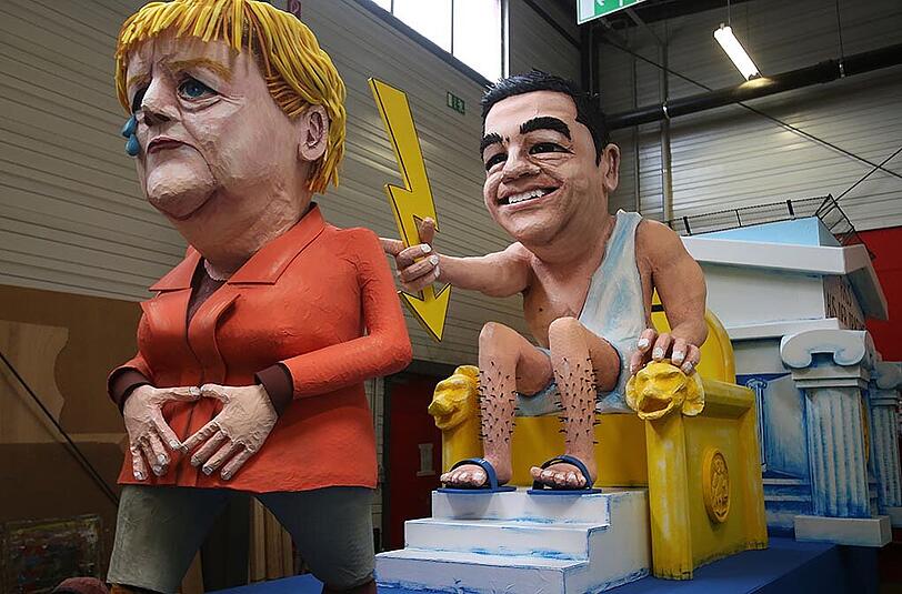 Die europäische Finanzkrise wird hier mit Alexis Tsipras und Angela Merkel abgebildet.