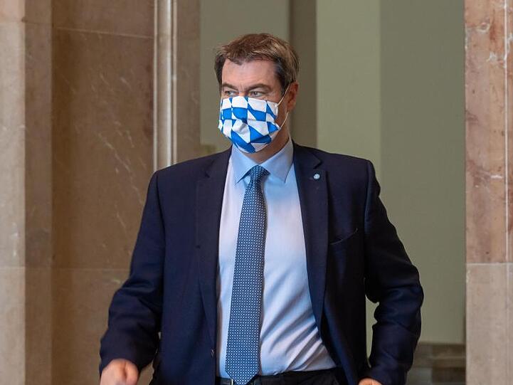 Ministerpräsident Markus Söder (CSU) mit einer Mundschutzmaske in weißblauem Rautendesign. Foto: Peter Kneffel/dpa/Archivbild