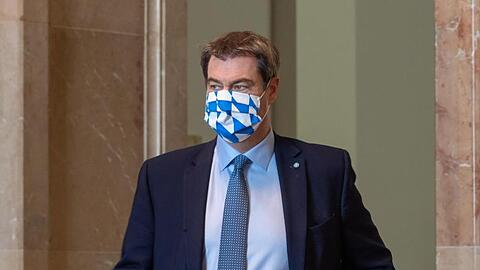 Ministerpräsident Markus Söder (CSU) mit einer Mundschutzmaske in weißblauem Rautendesign. Foto: Peter Kneffel/dpa/Archivbild