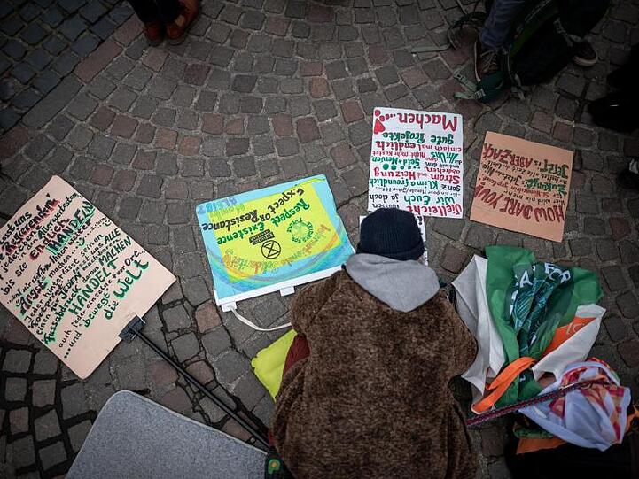 Eine Klima-Demonstrantin beschriftet Schilder. Foto: Fabian Strauch/dpa/Archivbild