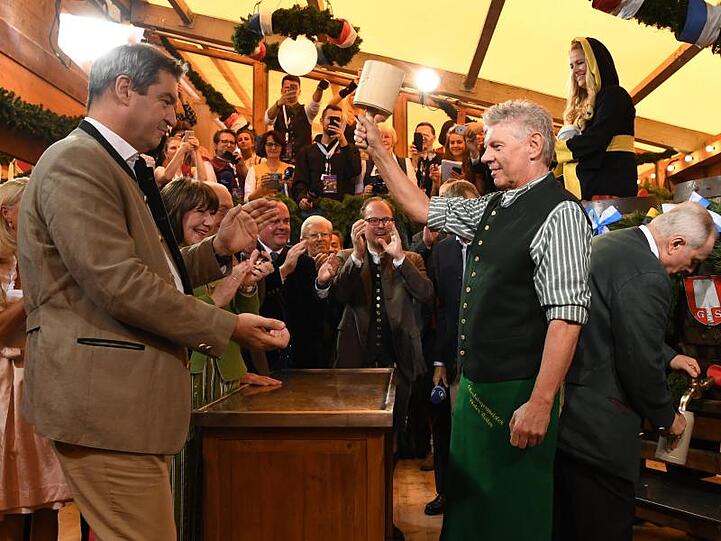 Markus Söder (l) schaut Dieter Reiter während des traditionellen Fassanstichs zu.