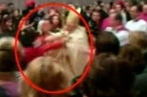 Dieses Bild, aufgenommen von einem italienischen TV-Sender zeigt die Szene, in der die Frau auf das Kirchenoberhaupt stürzt.