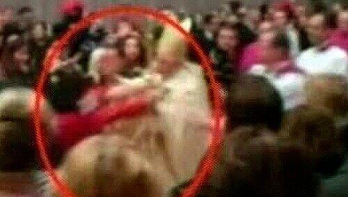 Dieses Bild, aufgenommen von einem italienischen TV-Sender zeigt die Szene, in der die Frau auf das Kirchenoberhaupt stürzt. Dieses Bild, aufgenommen von einem italienischen TV-Sender zeigt die Szene, in der die Frau auf das Kirchenoberhaupt stürzt.