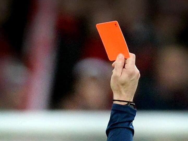 Ein Schiedsrichter zeigt einem Fußballspieler die rote Karte. Foto: Patrick Seeger/dpa/Symbolbild