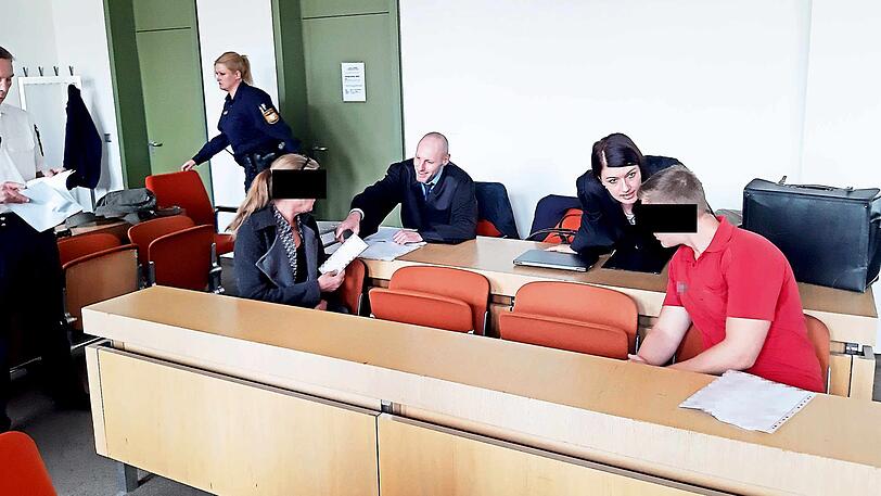 Mutter und Sohn auf der Anklagebank im Gespräch mit ihren Anwälten.