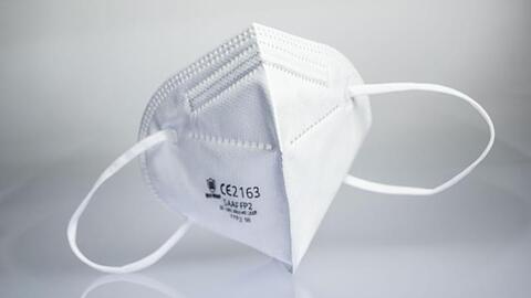 Eine FFP2-Maske liegt auf einem Leuchttisch.