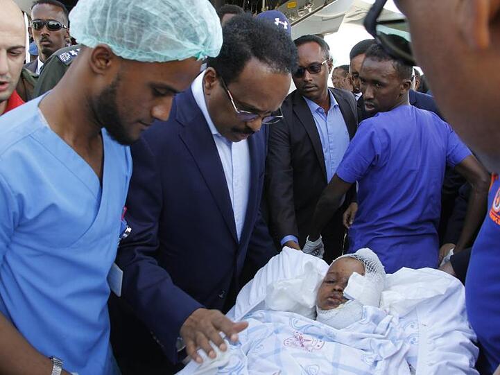Somalias Präsident Mohamed Abdullahi Mohamed (Mitte l) besucht Opfer, die bei der Explosion einer Autobombe am 28.12.2019 verletzt wurden.