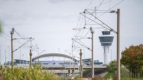 Leere Gleise der S-Bahn führen zum Flughafen München mit dem Tower im Hintergrund. Foto: Lino Mirgeler/dpa
