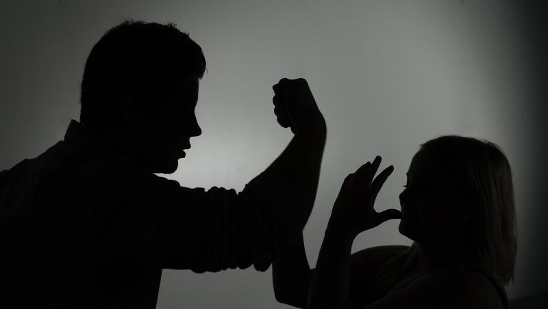 Ein als Silhouette abgebildeter Mann droht einer Frau mit der Faust. Foto: Jan-Philipp Strobel/dpa/Symbolbild