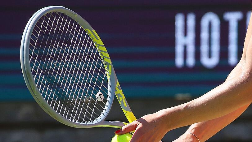 Eine Tennisspielerin bereitet einen Aufschlag vor.