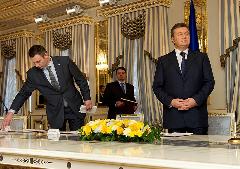 Einigung ja, Einigkeit nein: Oppositionspolitiker Vitali Klitschko hat im Vorfeld der Unterzeichnung des Abkommens die Namensschilder auf dem Tisch vertauscht, um nicht direkt neben dem ukrainischen Staatspräsident Viktor Janukowitsch (rechts) platziert zu sein.