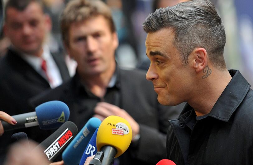 Weltstar im Fan-Gewusel: Robbie Williams verteilte Autogramme vor dem Mathäser-Kino.