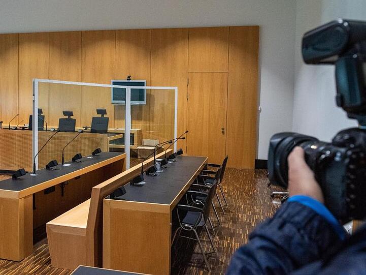 Im Landgericht Augsburg fotografiert vor dem Prozess gegen den Fußballprofi Caiuby ein Journalist die leere Anklagebank. Foto: Stefan Puchner