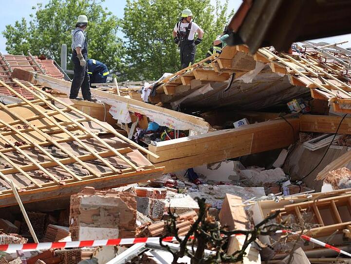 Einsatzkräfte in den Trümmern des zerstörten Hauses im bayerischen Rettenbach.