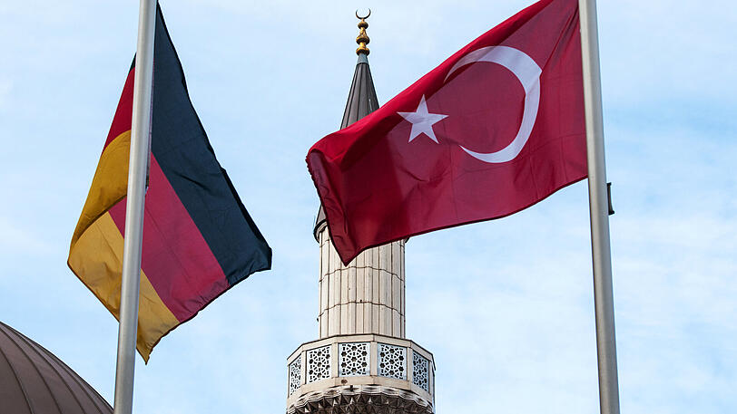 Eine deutsche und eine türkische Fahne wehen in Duisburg-Marxloh (Nordrhein-Westfalen) vor einer Moschee.