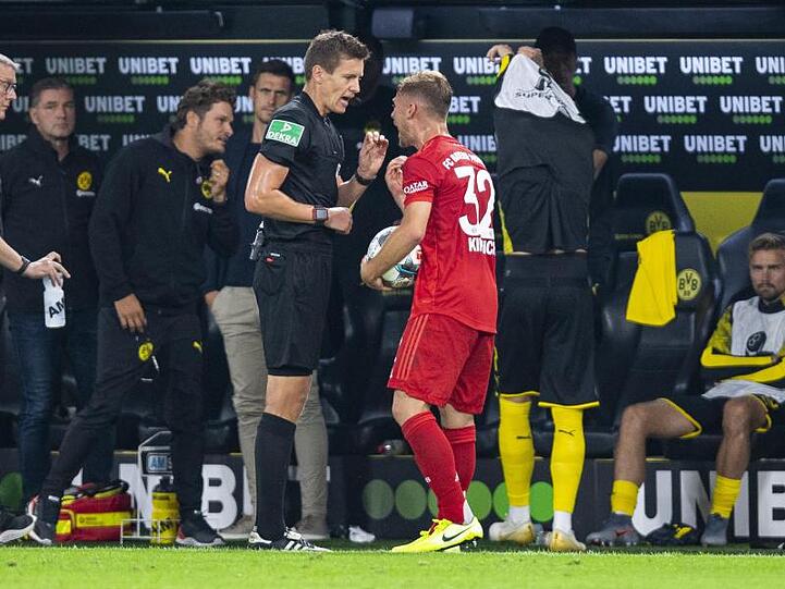 Bayerns Joshua Kimmich (r) diskutiert nach der Gelben Karte mit Schiedsrichter Daniel Siebert. Foto: Guido Kirchner/Archivbild