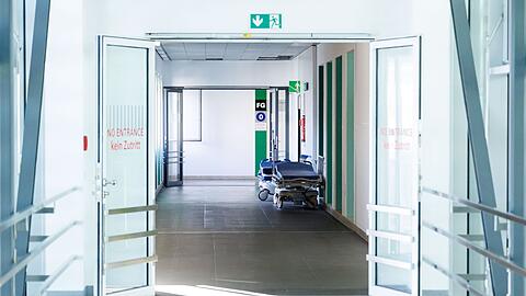 Krankenbetten stehen in einem Gang in einem Krankenhaus.