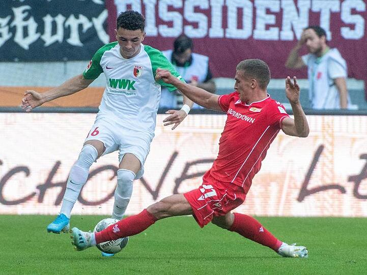 Ruben Vargas von Augsburg und Berlins Grischa Prömel (l-r.) im Zweikampf um den Ball. Foto: Stefan Puchner
