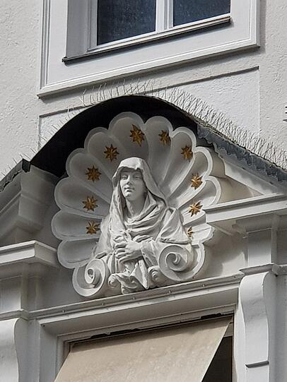 Diese Maria lächelt in der Kaufingerstraße über dem Einkaufstrubel.