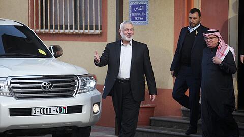 Ismail Hanijeh (l), der Chef der Hamas, geht mit dem Botschafter Katars für die Palästinensischen Autonomiegebiete, Mohammed al-Amadi (r), aus dem Haus.