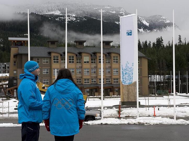 Zwei freiwillige Helfer stehen in Whistler vor dem Olympischen Dorf.