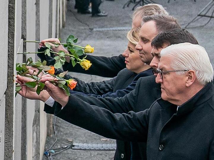 Bundespräsident Frank-Walter Steinmeier (r-l), und die Präsidenten Janos Ader (Ungarn), Andrzej Duda (Polen), Zuzana Caputova (Slowakei) und Milos Zeman (Tschechien) stecken Blumen in die Hinterlandmauer.