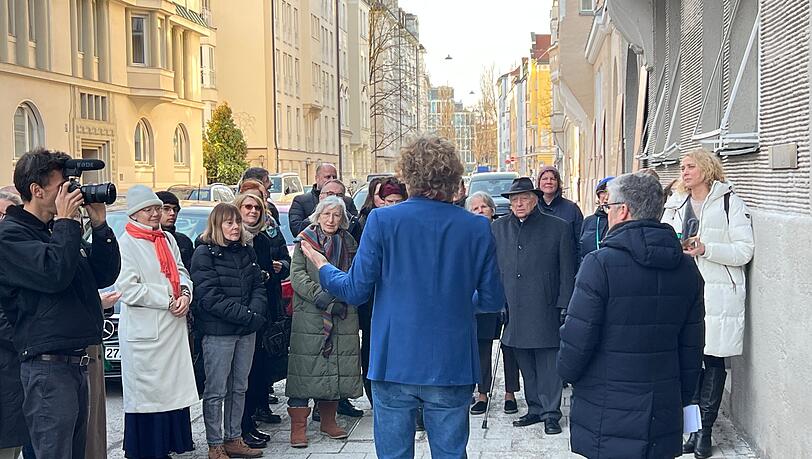 Matthias Georgi (im blauen Jackett) spricht zu den G&auml;sten der Zeremonie in der Ohmstra&szlig;e &ndash; rechts neben ihm Stadtrat Winfried Kaum (CSU) als Vertreter des Oberb&uuml;rgermeisters.