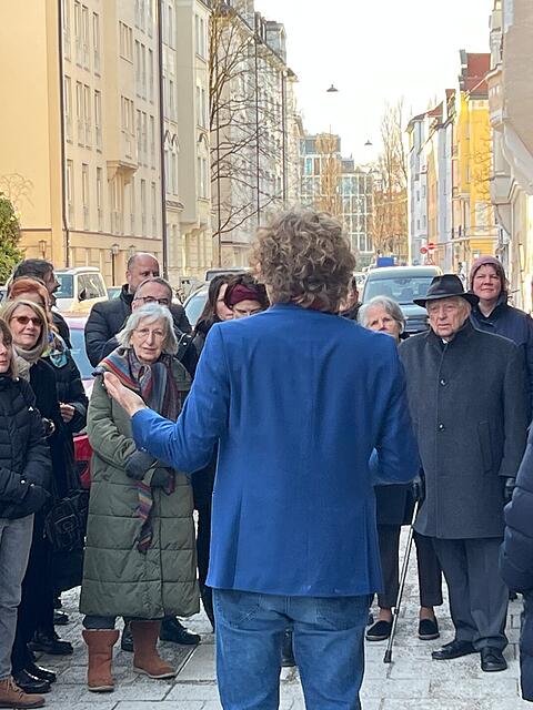 Matthias Georgi (im blauen Jackett) spricht zu den G&auml;sten der Zeremonie in der Ohmstra&szlig;e &ndash; rechts neben ihm Stadtrat Winfried Kaum (CSU) als Vertreter des Oberb&uuml;rgermeisters.
