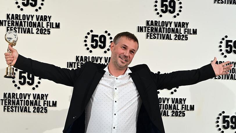 Der slowakische Regisseur Miro Remo posiert mit seiner Auszeichnung in der Hand. Miro gewann den Hauptpreis des 59. Karlsbader Filmfestivals.