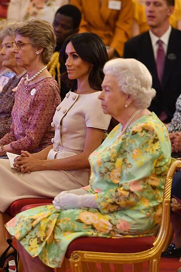 Beim Queen's Young Leaders Award sitzt Herzogin Meghan im beigen Kleid neben Queen Elizabeth II. im bunten Rosenkleid.