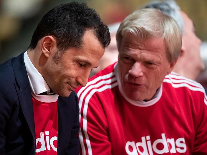 Hasan Salihamidzic (l) und Oliver Kahn sitzen bei einer Versammlung zusammen. Foto: Sven Hoppe/dpa/Archiv