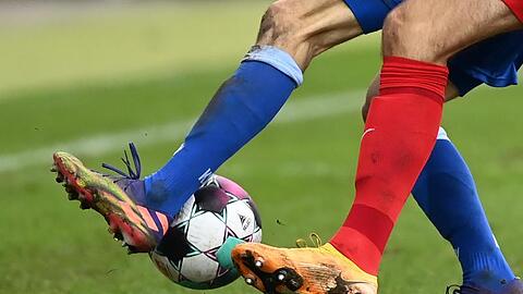 Zwei Fußballspieler kämpfen um den Ball.