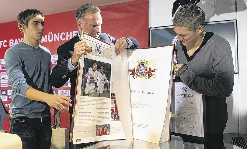 Philipp Lahm, Karl-Heinz Rummenigge und Bastian Schweinsteiger müssen die Chronik zu dritt anpacken.