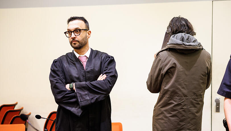 Der angeklagte Mann, der seine Gönnerin aus Habgier getötet haben soll (r), steht vor Prozessbeginn in einem Gerichtssaal vom Landgericht neben seinem Rechtsanwalt Adam Ahmed.