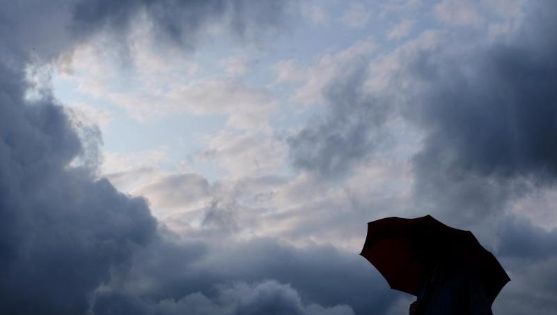Ein Mann geht mit einem Regenschirm vor aufziehenden dunklen Wolken spazieren. Foto: Martin Gerten/Archivbild Ein Mann geht mit einem Regenschirm vor aufziehenden dunklen Wolken spazieren. Foto: Martin Gerten/Archivbild