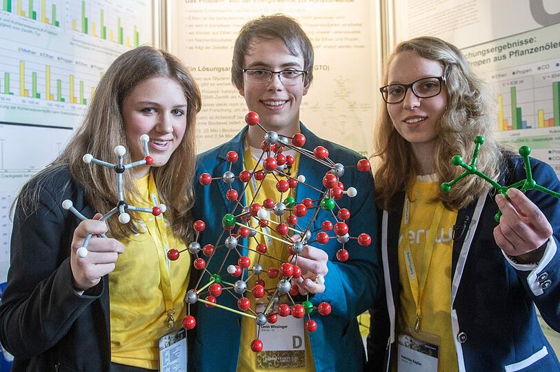 Die Sieger im Fachgebiet Chemie: Larissa Roth (l-r, 17 Jahre), Levin Winzinger (16 Jahre) und Felicitas Kaplar (18 Jahre) vom Hanns-Seidel-Gymnasium Hösbach, präsentieren ihre Forschungsergebnisse zur Gewinnung sogenannter "Grüner Olefine" aus nachwachsenden Rohstoffen.