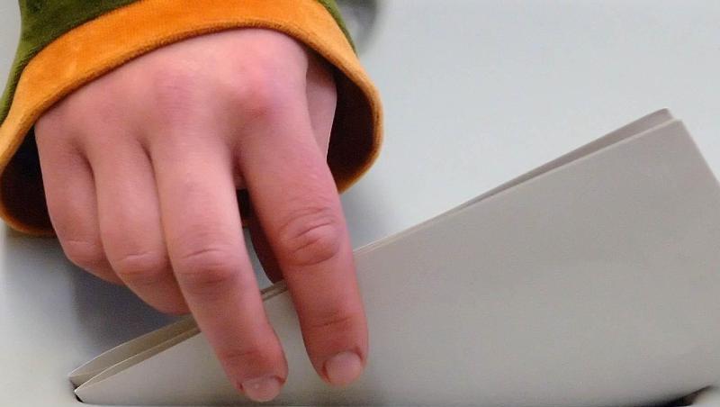 Eine jugendliche Hand steckt einen Stimmzettel in eine Wahlurne. Eine jugendliche Hand steckt einen Stimmzettel in eine Wahlurne.