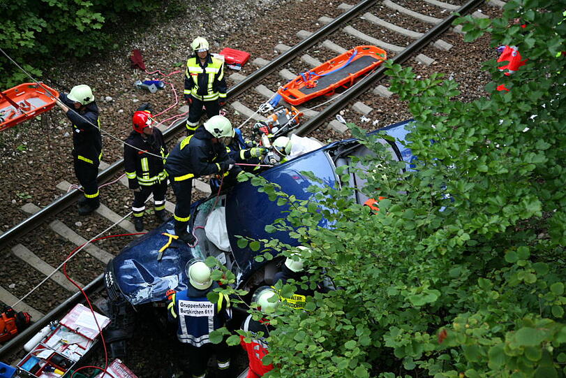 Furchtbarer Unfall im Landkreis Altötting: Ein PKW fliegt von einer Brücke herunter und knallt auf das Gleisbett. Drei junge Menschen kommen schwer verletzt in die Klinik.