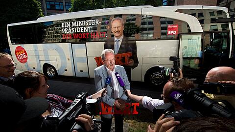 So liebt er das: Der SPD-Spitzenkandidat Christian Ude vor seinem neuen Wahlkampfbus - und viele Mikrofone sind auf ihn gerichtet.