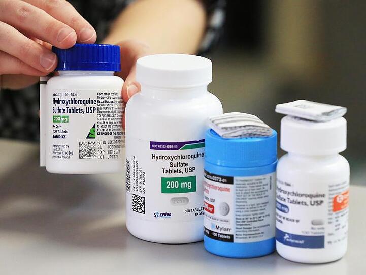 Ein Apotheker zeigt in einer Apotheke Dosen mit dem Medikament Hydroxychloroquin von verschiedenen Herstellern (Symbol).