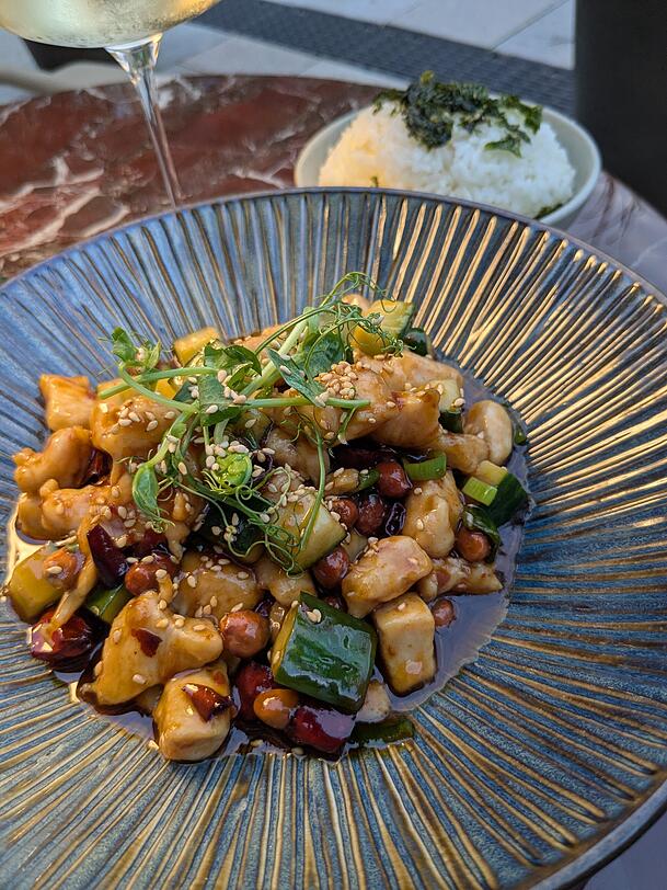 Die Hauptspeise: H&uuml;hnerfilet gebraten mit Erdn&uuml;ssen, Fr&uuml;hlingszwiebeln, Sichuan-Pfeffer und Chili in s&uuml;&szlig;-saurer So&szlig;e.
