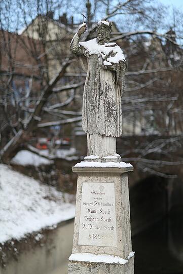 Die Brückenfigur zur Praterinsel trägt ein Cape aus Neuschnee.